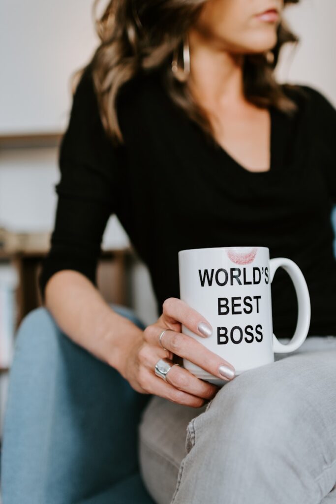 woman in black long sleeve shirt holding white ceramic mug. Manifestor Human Design type image of a boss lady